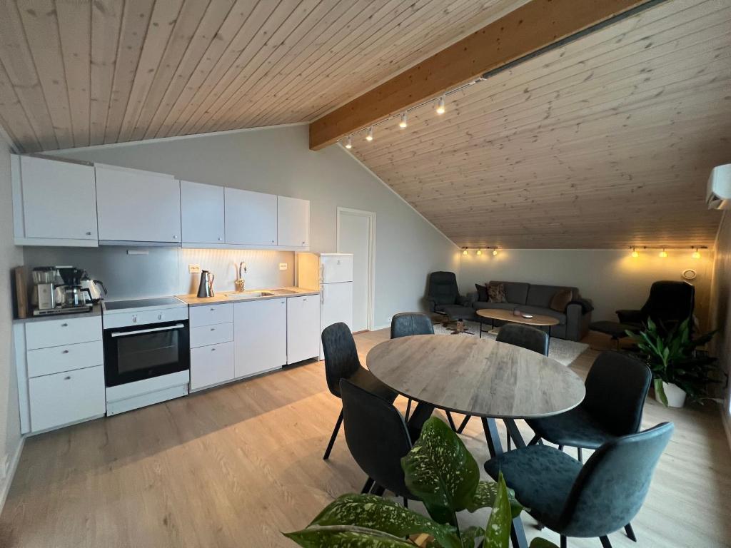 a kitchen and living room with a table and chairs at The House by the Sea in Straumsbukta