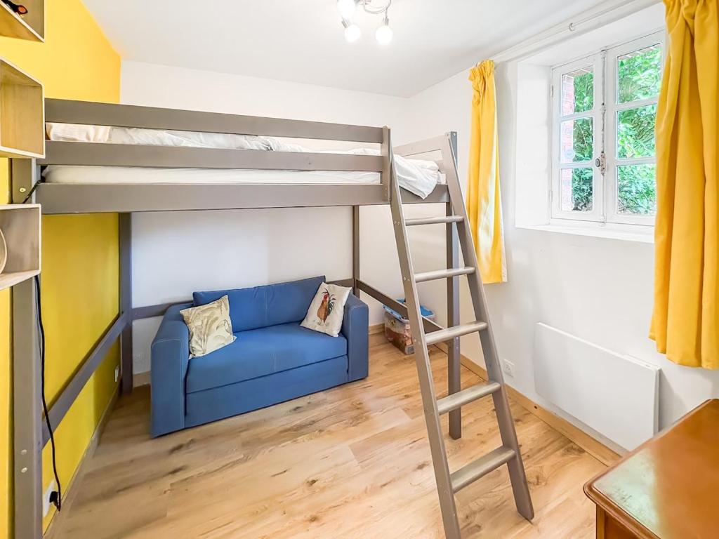 a room with a bunk bed and a blue couch at La Maison du Lac in La Ferté-Macé