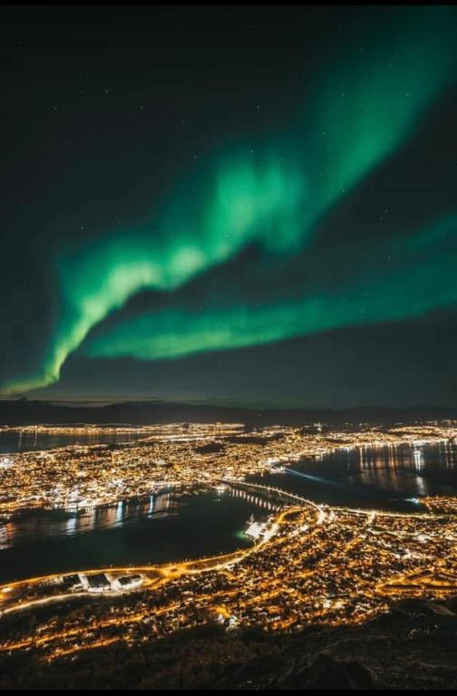 an aerial view of a city with the green northern lights at Leiligheten in Trondalen