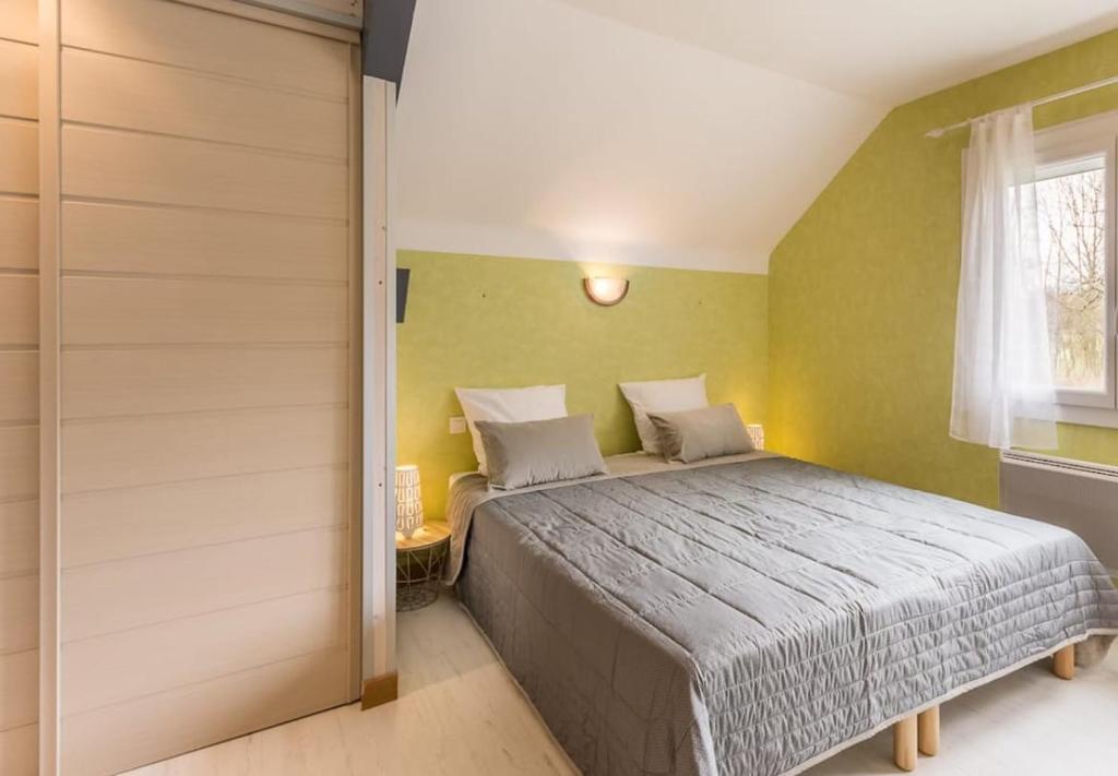 ein Schlafzimmer mit großem Bett und Fenster in der Unterkunft Nature & Calme en Montagne De 2 à 6 Couchages in Saint-Offenge-Dessous