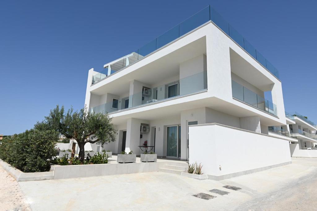 a white house with a lot of windows at Dara Holiday Apartments in Marsala