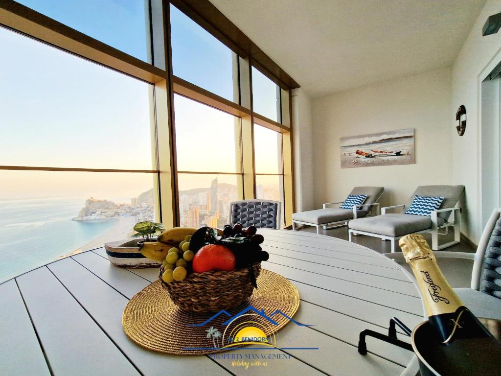 a basket of fruit on a table in a room with windows at Intempo Golden Magic Sky Resort & Spa in Benidorm