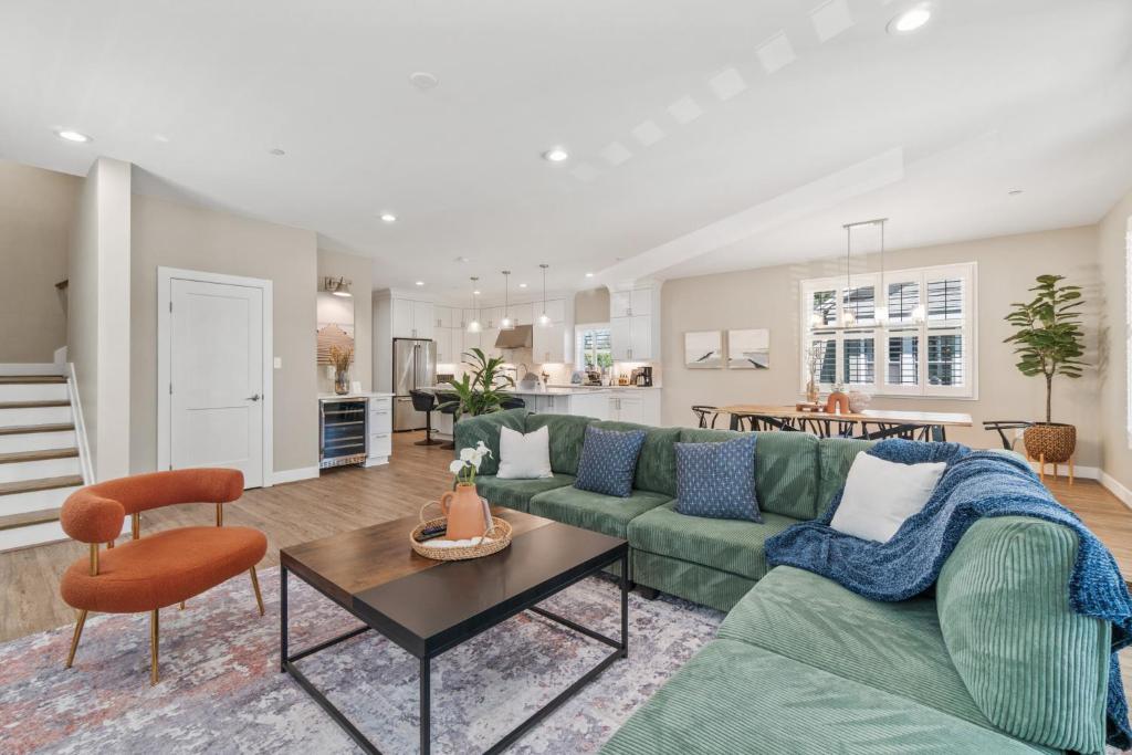 a living room with a green couch and a table at Brand New Spacious Luxury Home in Annapolis