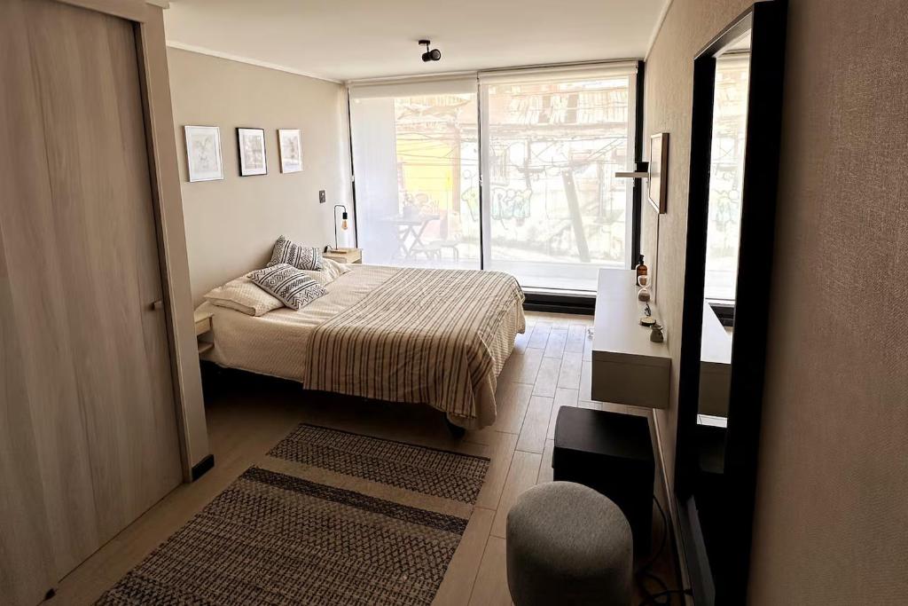 una piccola camera da letto con un letto e una finestra di Departamento estudio con terraza vista al mar a Valparaíso