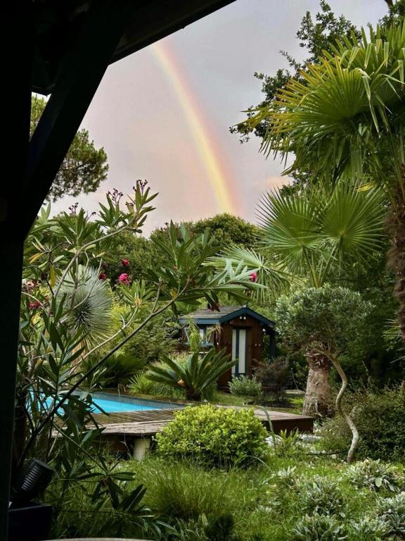 a rainbow over a house with a pool and trees at Cap Mango Paradise in Capbreton