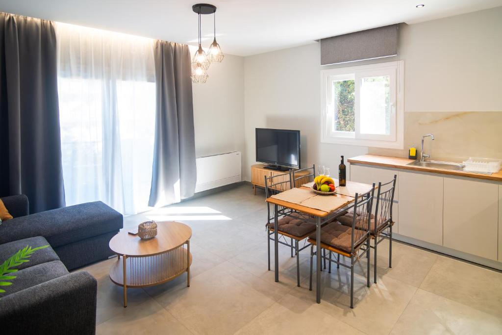 a living room with a couch and a table and a kitchen at Μilia Olive&Terra Apatments in Kynopiástai