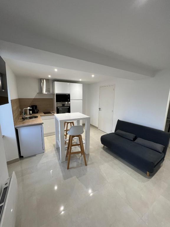 a living room with a white table and a blue couch at La Basse Meule Maison in Juvigné