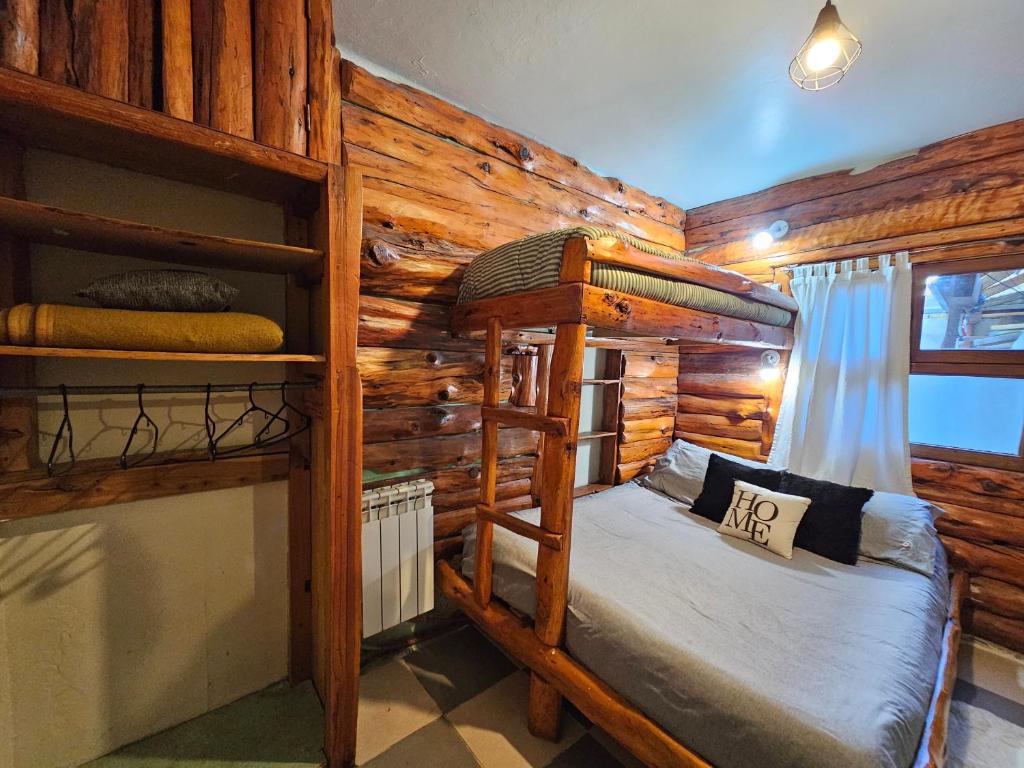 a bedroom with two bunk beds in a log cabin at Refugio Aku in San Carlos de Bariloche