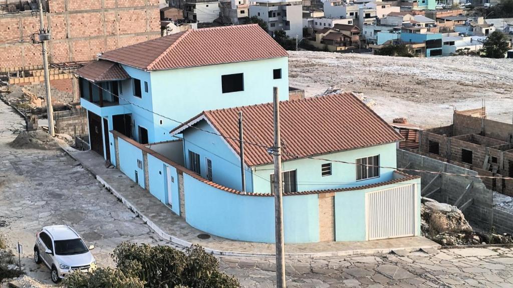 a blue and white house with a car parked next to it at Casa Beija Flor in São Thomé das Letras