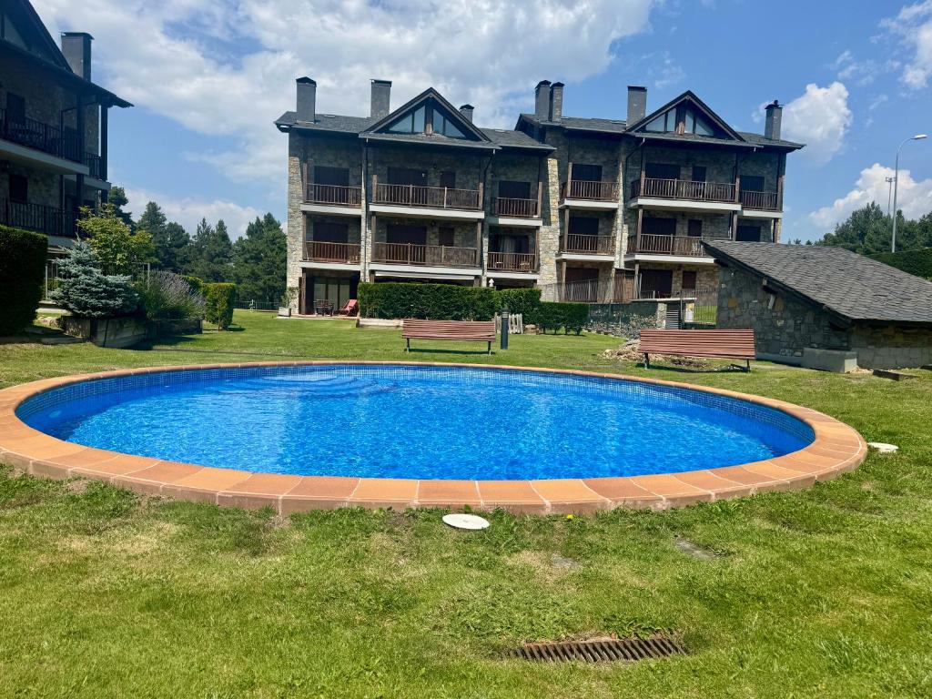 a swimming pool in front of a large building at Ático duplex a pie de pistas de esquí in La Molina