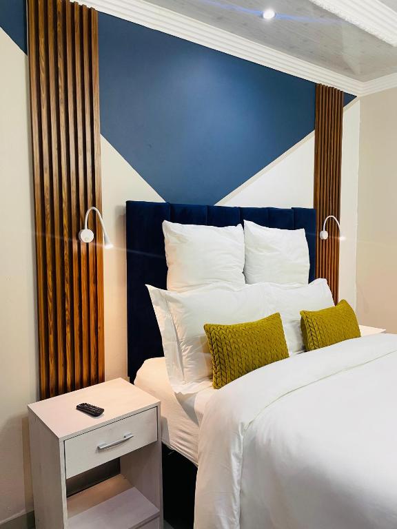 a bedroom with a large bed with a blue wall at The Success Guest House in Standerton