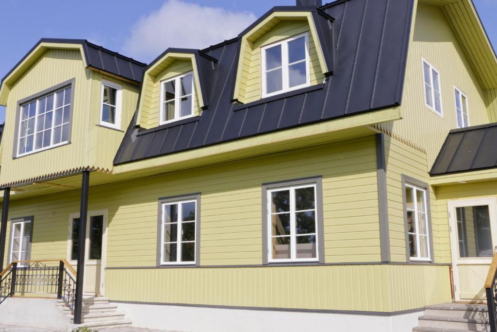a house with yellow and black roof at Kärdla Retrovisiit Kirsi, Tiina ja Linda in Kärdla