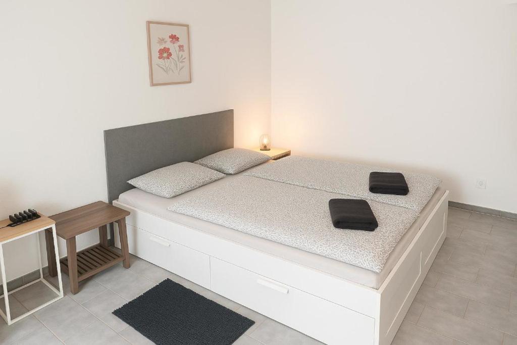 a bedroom with a bed with two black cushions on it at Ubytování na faře in Prague