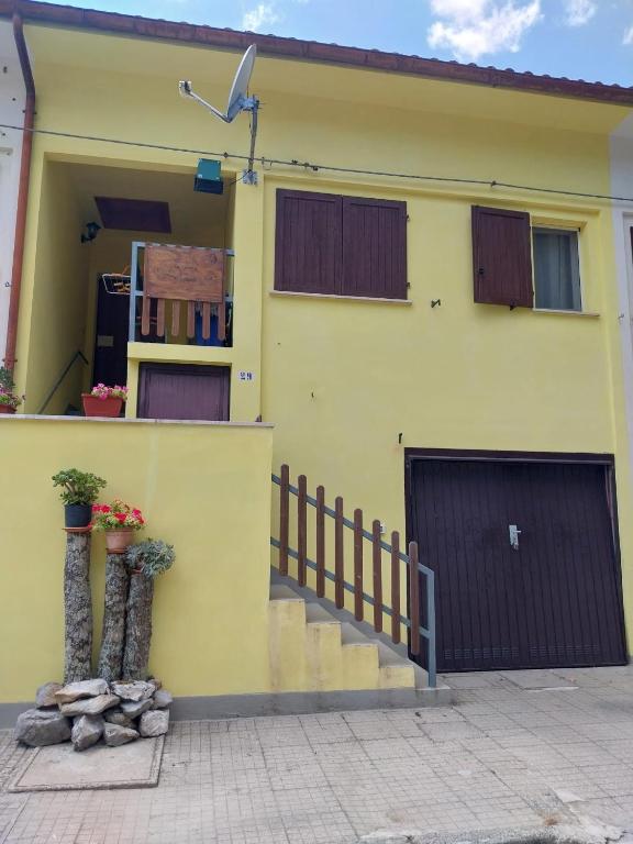 a yellow house with two garage doors at La Perla del Dolcedorme in San Lorenzo Bellizzi