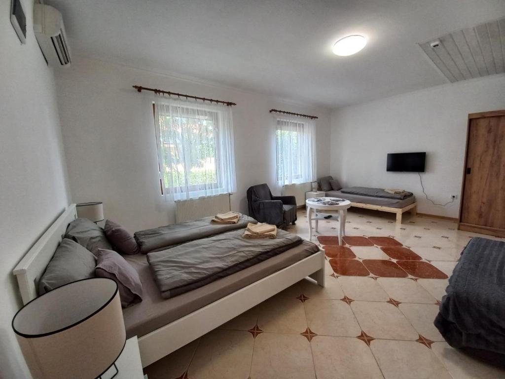 Un dormitorio con una cama grande y una sala de estar. en Lukács apartman, en Gyula