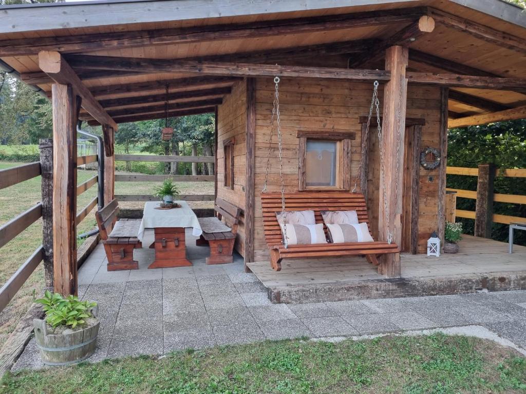 a wooden cabin with a bench and a table at western cottage in Rečica ob Savinji