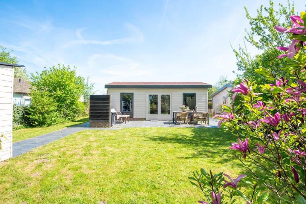 a home with a yard with a house at Duynhof nabij Strand, duinen, bos en stad - 5 personen in Warmenhuizen