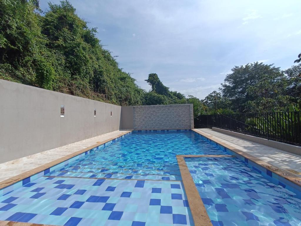 a swimming pool with blue tiles on the ground at centrico Apartamento con piscina Anapoima in Anapoima