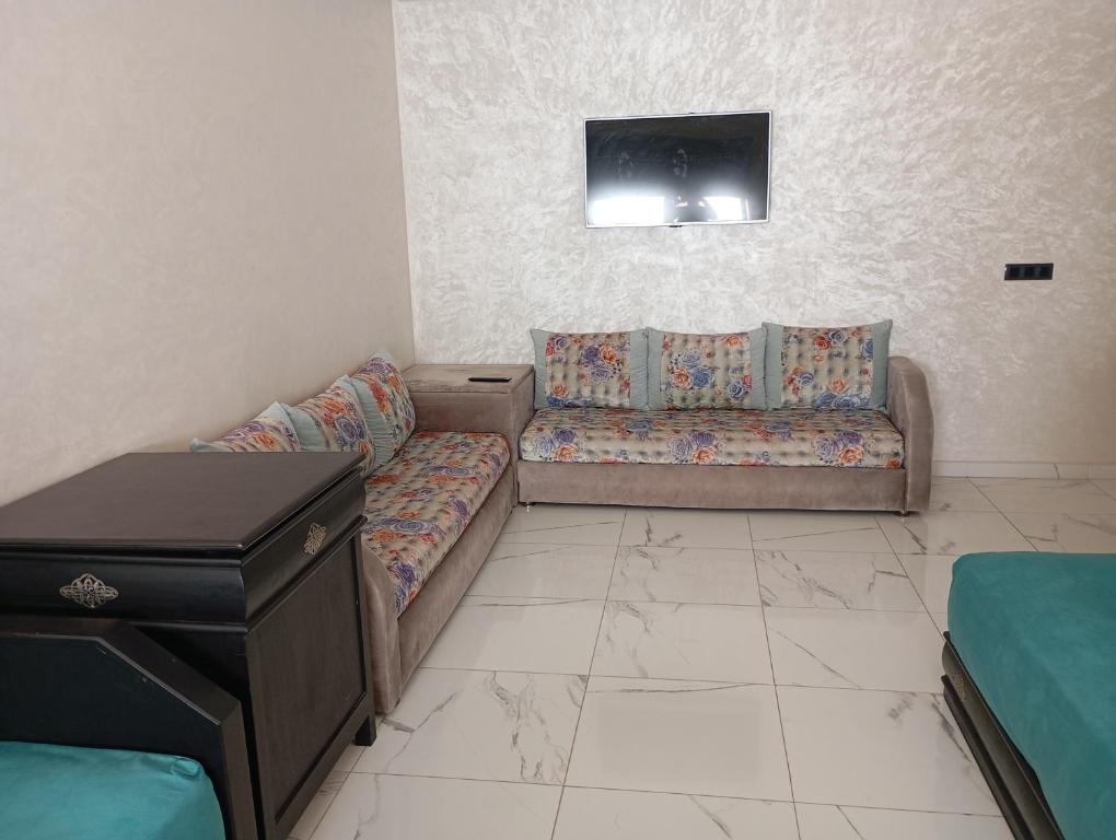 a living room with a couch and a tv at للا ربيعة بيتي in Kenitra