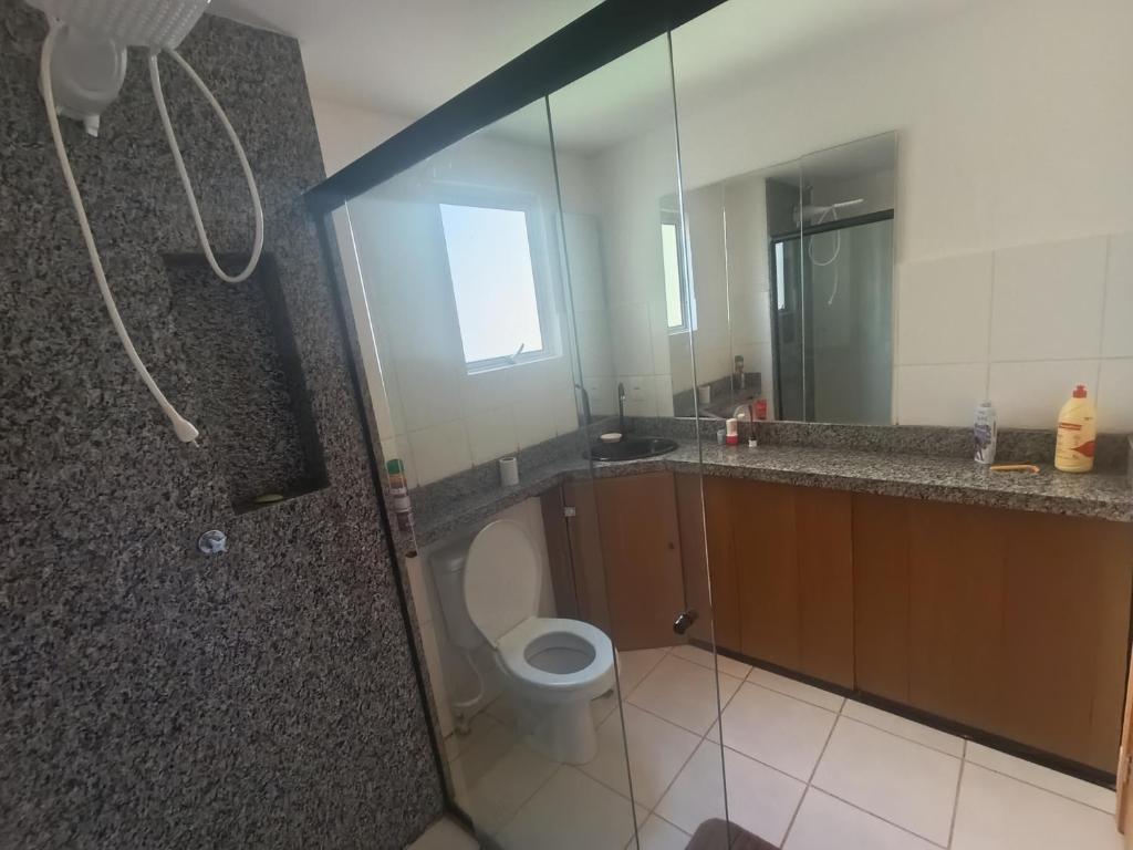 a bathroom with a shower and a toilet and a mirror at Apartamento aconchegante in Brasilia