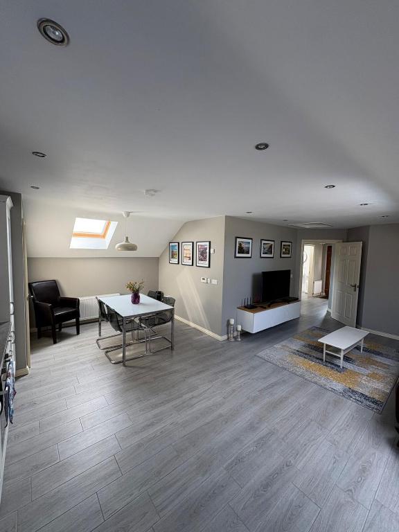 a living room with a table and a couch at Modern Country Loft, Ballymena in Teeshan