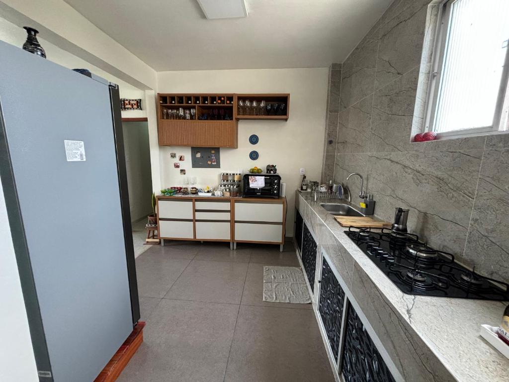 una cucina con lavandino e piano cottura di Quarto individual ou casal a Belém