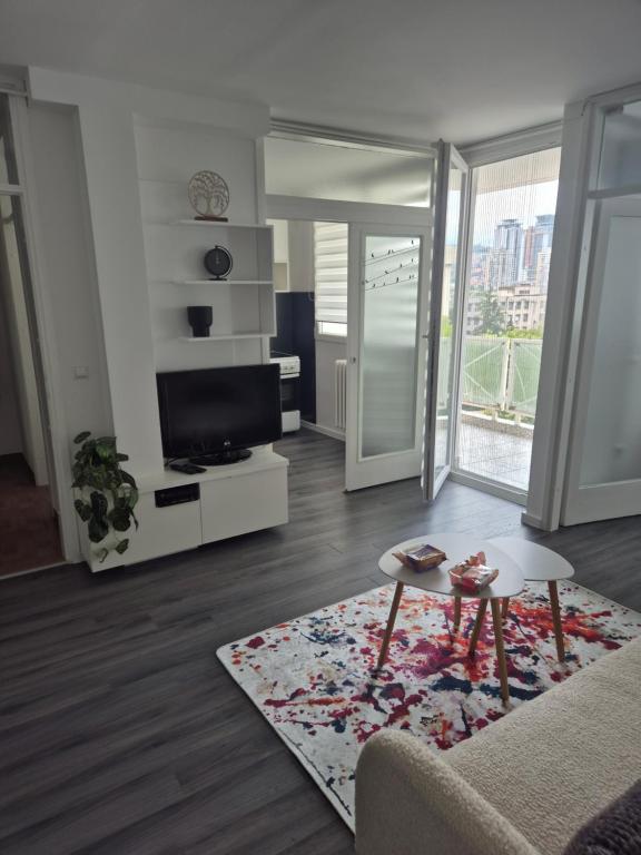 salon z kanapą, telewizorem i stołem w obiekcie Sarajevo apartman w Sarajewie