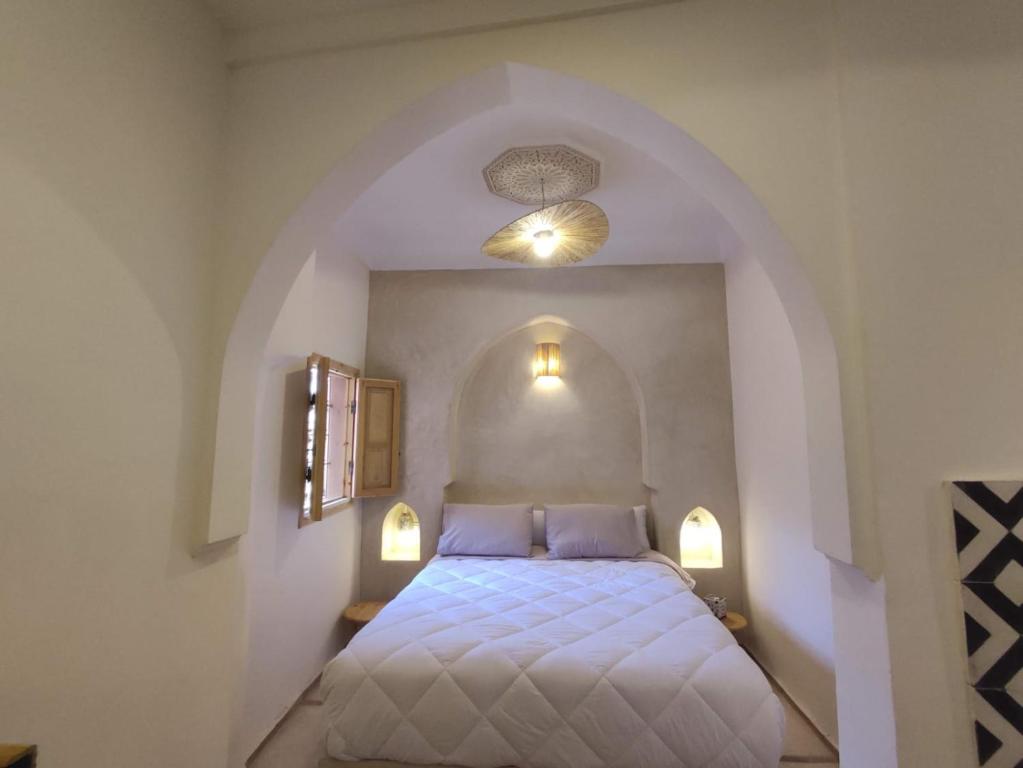 une chambre avec un lit avec deux oreillers dans l'établissement Riad E&J Marrakech Médina 5 ch climatisées, piscine chauffée, EXCLUSIF, à Marrakech