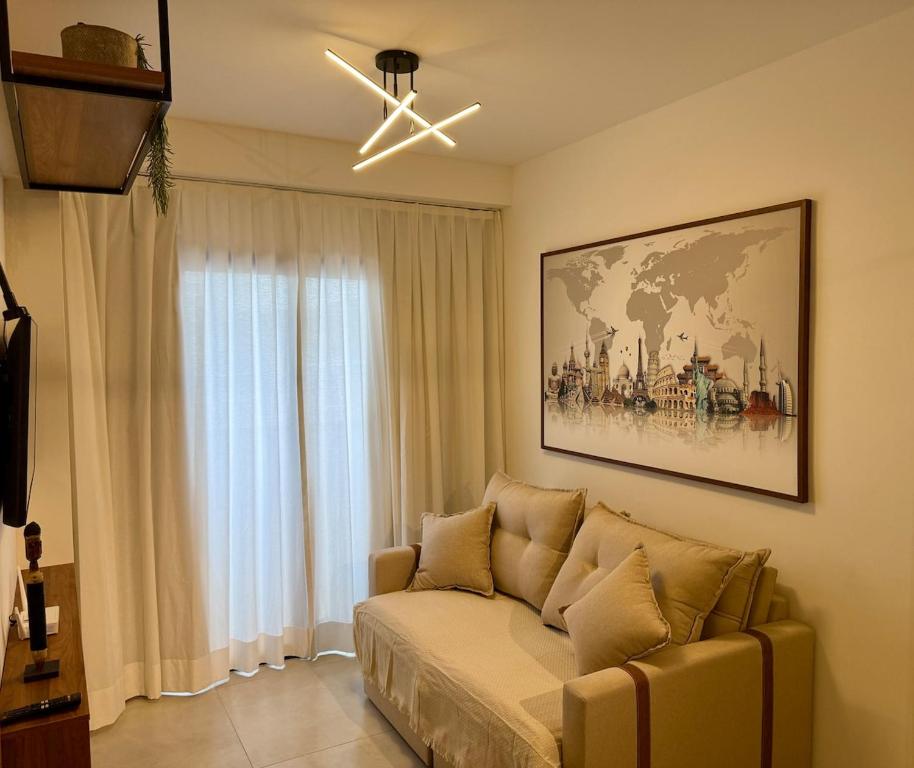 a living room with a couch and a ceiling fan at Downtown 2 Suites Piscina, ar, academia, cowork e vaga in Juiz de Fora
