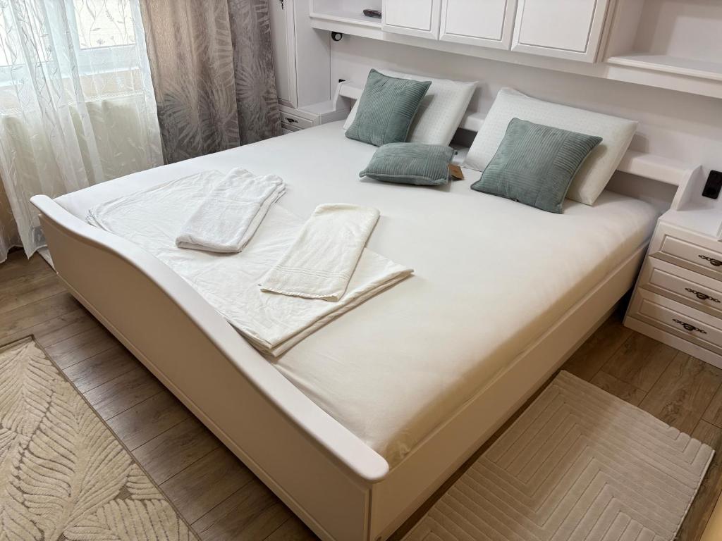 a large bed with two napkins and towels on it at Apartament Leonardo in Roman