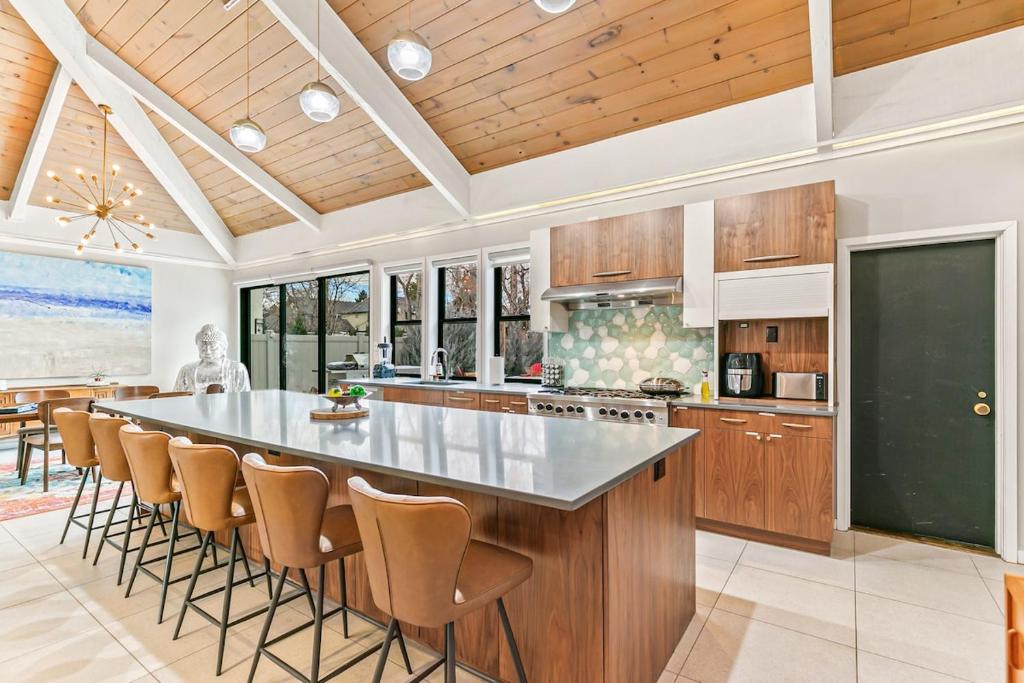 a kitchen with a large island with bar stools at Artful Stay, Downtown, Spacious, LED Art, Hot Tub in Denver