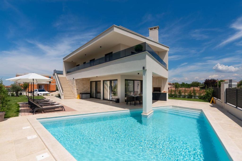 a villa with a swimming pool and a house at Villa Perla in Poreč
