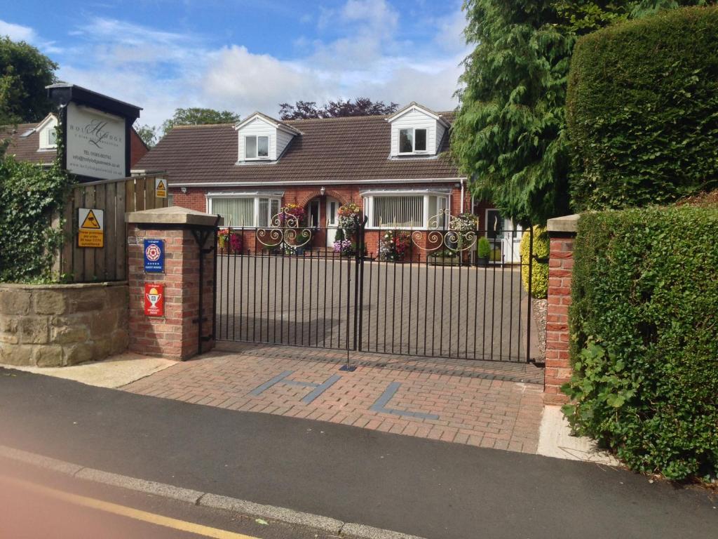uma casa com um portão em frente em Holly Lodge em Alnwick