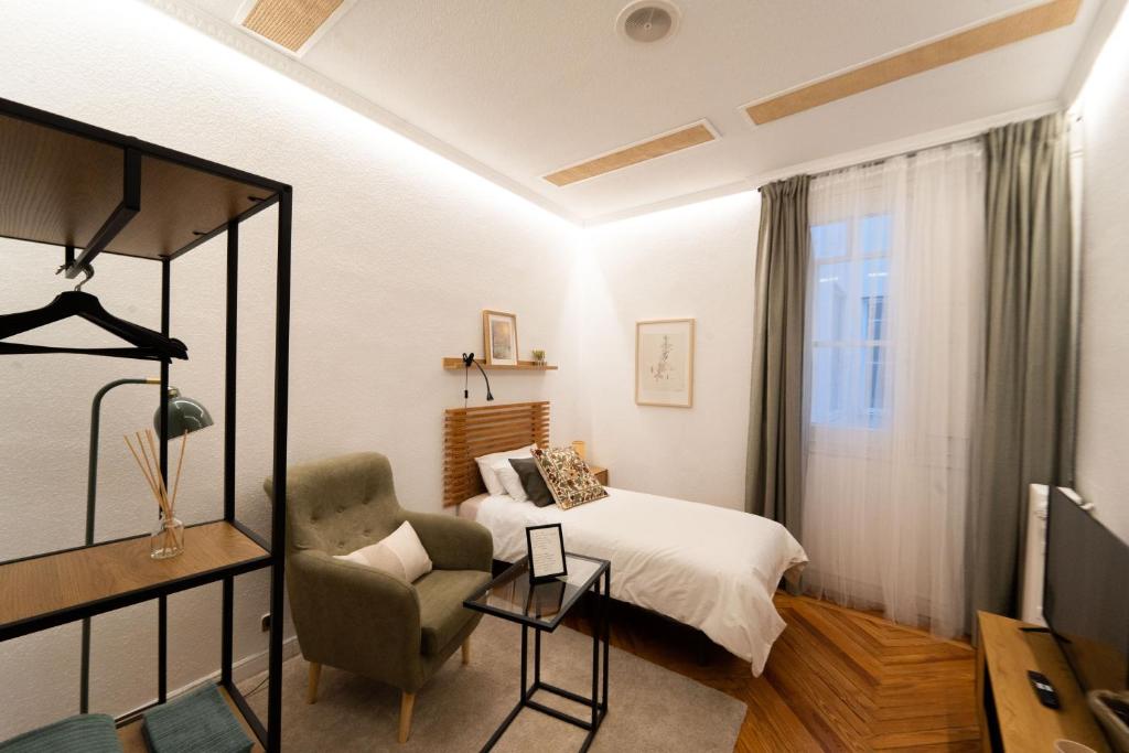 a bedroom with a bed and a chair at Alojamiento Pleno Centro Fuencarral in Madrid
