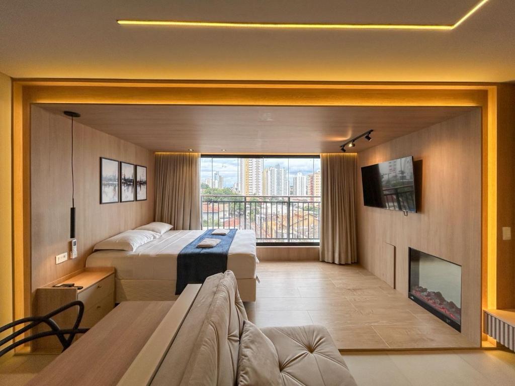 a hotel room with two beds and a fireplace at Flat Aconchego Urbano in Campo Grande