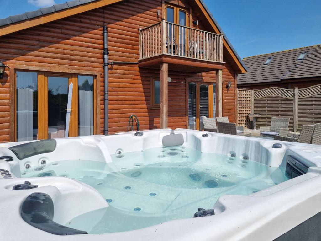 un bain à remous en face d'une maison en rondins dans l'établissement Cherry 30 Hot Tub-2 Storey, à Hull
