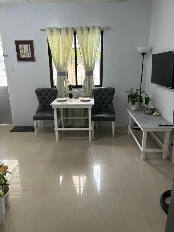 a living room with two chairs and a table at Casa Residence by Baluyut in Concepcion