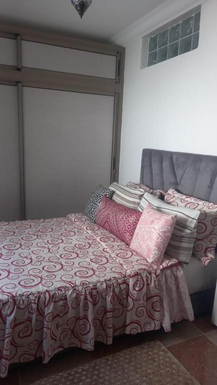 a bedroom with a bed and pillows on it at khadija oulidia in Oualidia