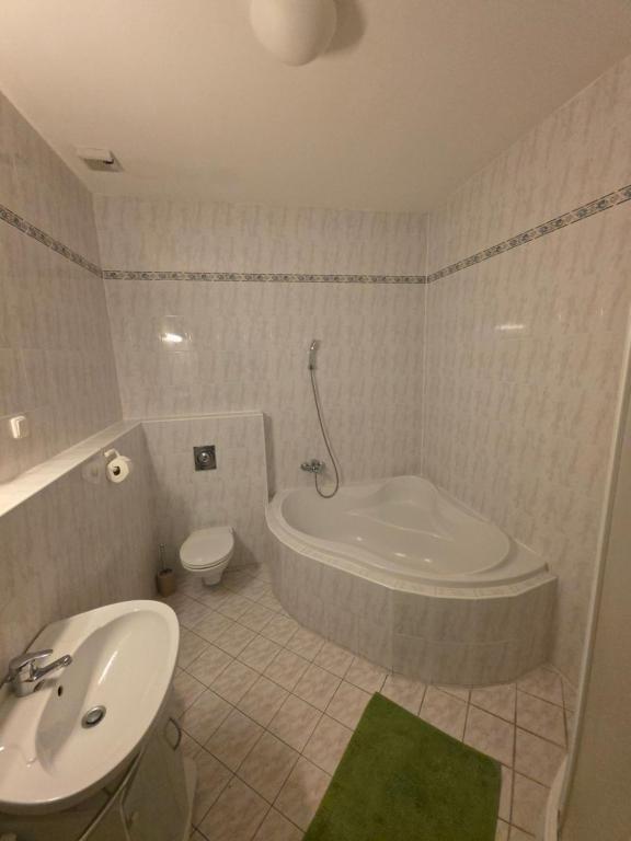 a bathroom with a tub and a toilet and a sink at Hostel One in Bratislava