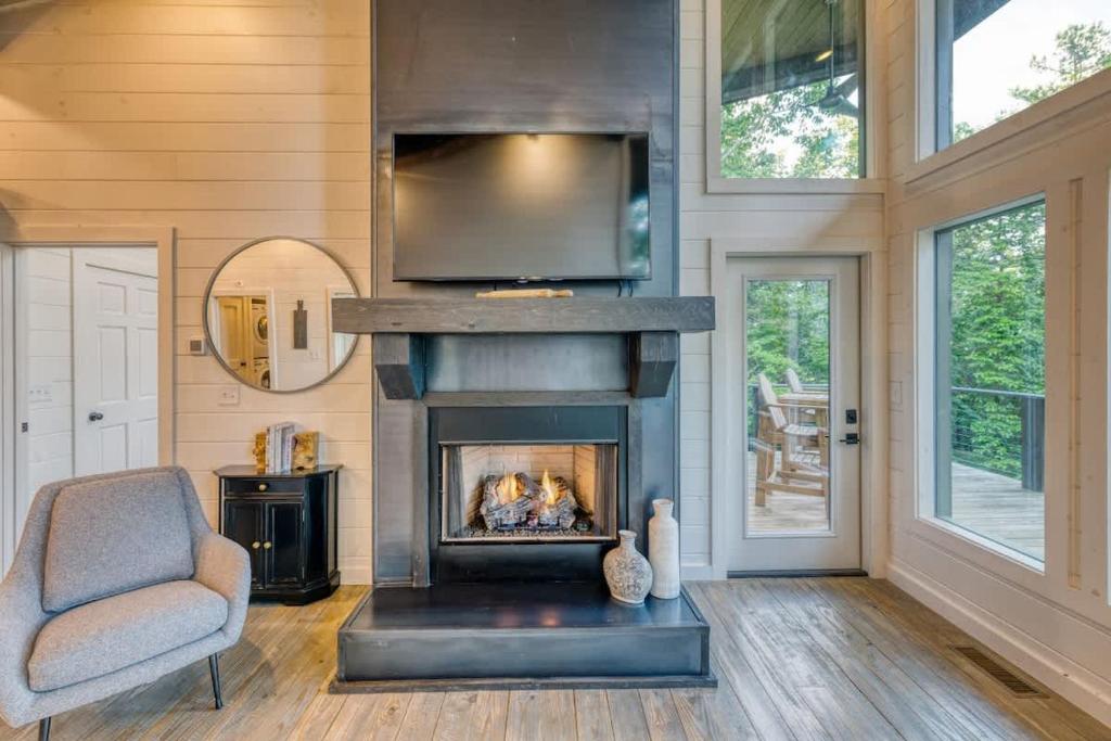 een woonkamer met een open haard en een stoel bij Mountain Abode - Luxury Cabin with Hot Tub in Blue Ridge