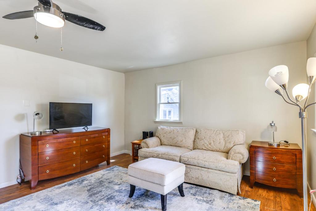 a living room with a couch and a tv at 1 Mi to Dtwn Saratoga Springs Cozy Duplex Apt! in Saratoga Springs