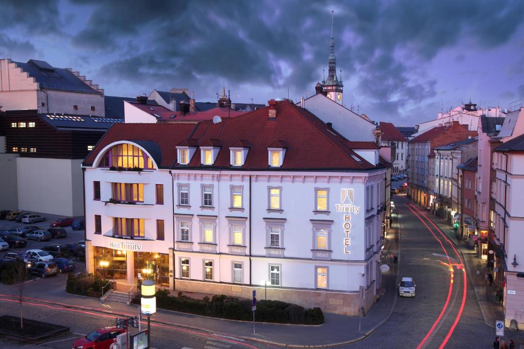 a large white building on a city street at night at Hotel Trinity in Olomouc