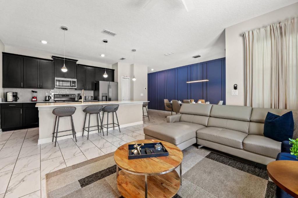 a living room and kitchen with a couch and a table at Near Disney 4BR with Private Pool in Kissimmee
