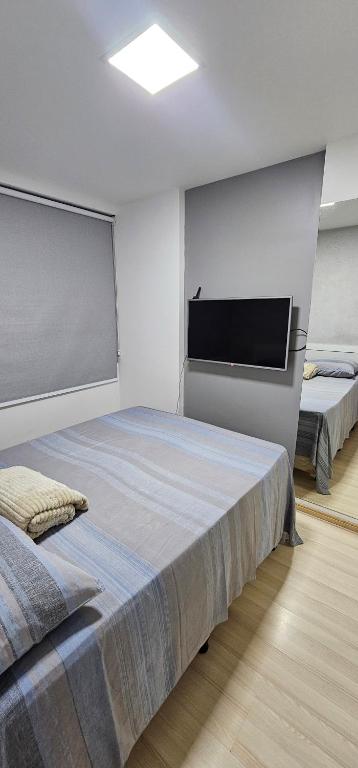 una camera da letto con due letti e una TV a schermo piatto di Apartamento no Edifício Manhattan - Bairro Nobre de Caruaru a Caruaru