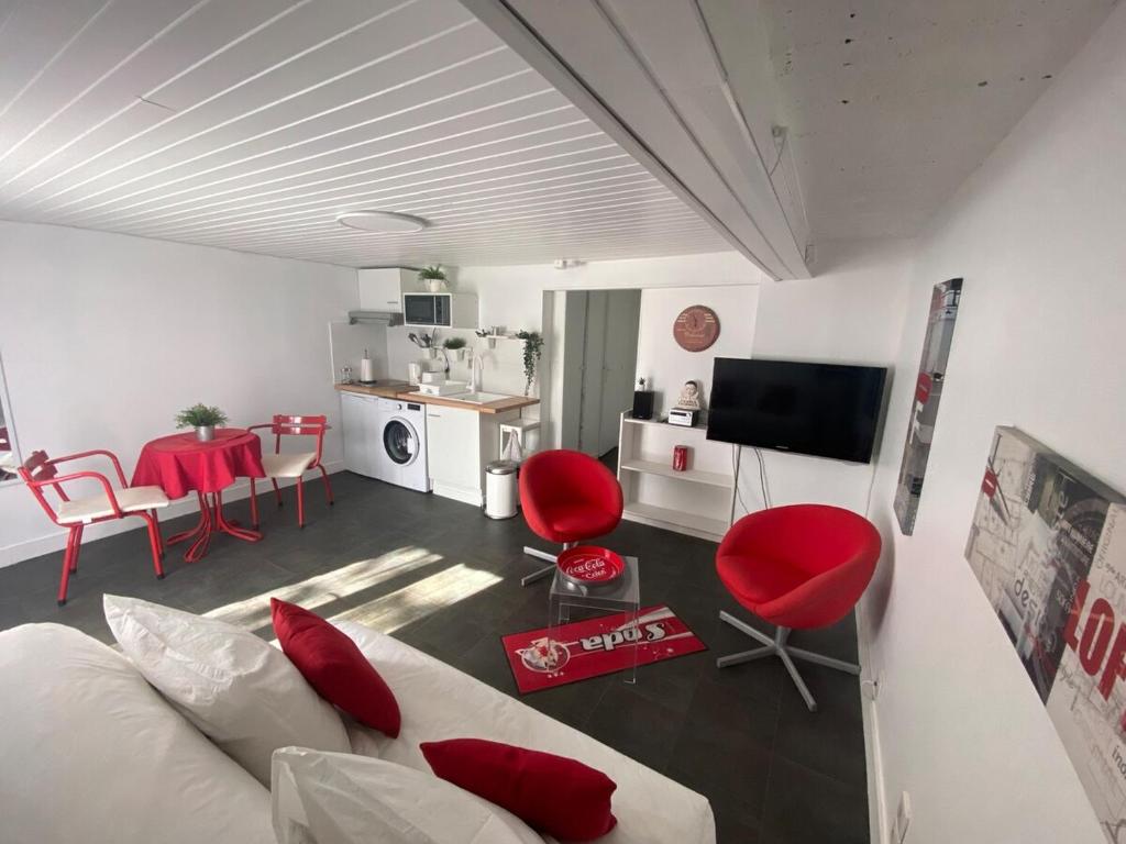 a living room with a white couch and red chairs at Coca-Cola Studio near Paris in Saint-Denis