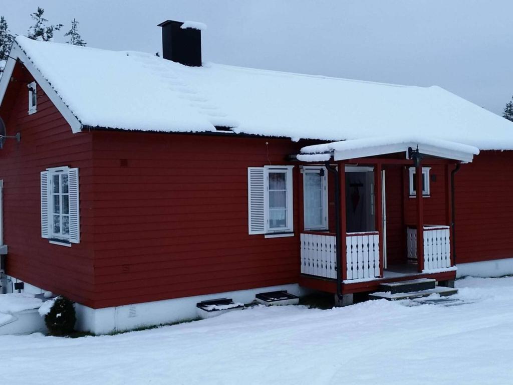 una casa roja con nieve en el techo en 6 person holiday home in Osen, en Vika