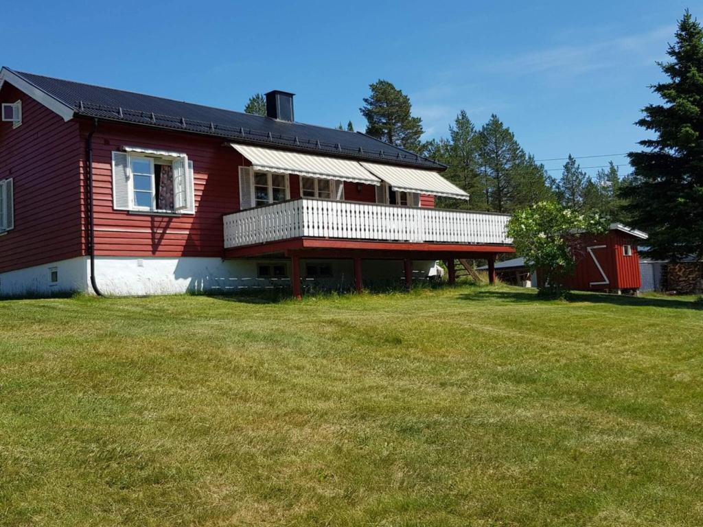 a red house with a large yard in front of it at 6 person holiday home in Osen in Vika