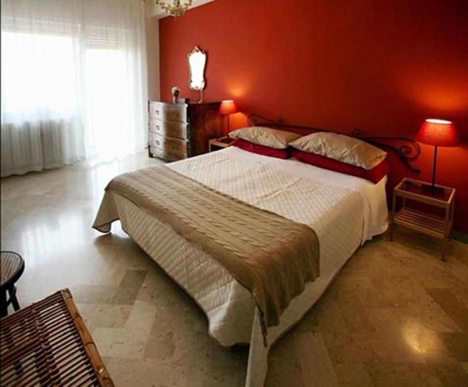 a bedroom with a large bed with a red wall at Smile House in Matera