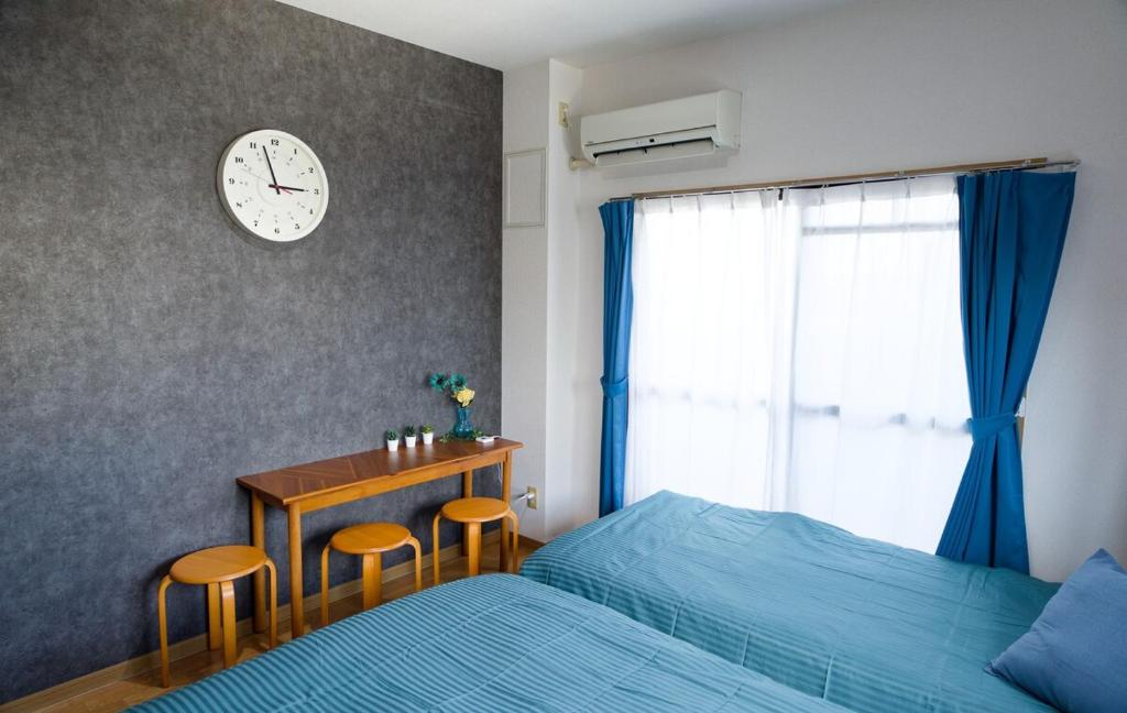 a bedroom with a bed and a desk and a clock at G63 駅徒歩3分 3人可能 名古屋駅から1駅 3-minute walk from the station in Nagoya