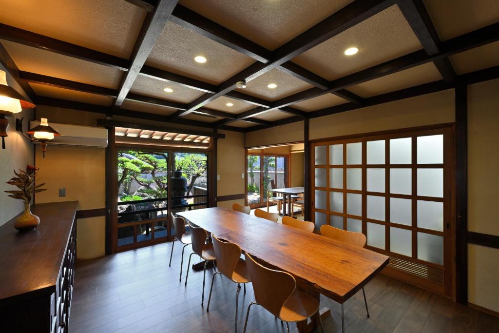 a dining room with a large wooden table and chairs at 島宿栞 in Tonosho